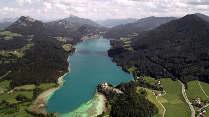 Blick von oben auf den Fuschlsee, eingebettet in bewaldete Berge