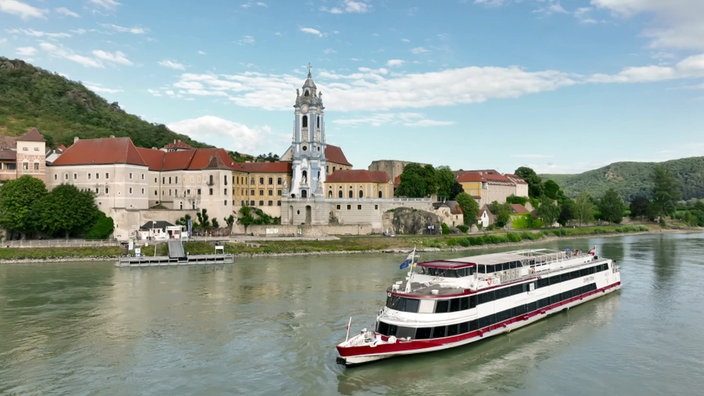 Personenschiff auf der Donau, am Ufer ein Ort mit Kirche mit blauem Turm