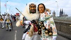 Teilnehmer des Rosenmontagszuges überqueren als Novum in der 200-jährigen Geschichte der Parade die Deutzer Brücke.