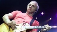 Blick von unten auf Mark Knopfler, Gitarre spielend