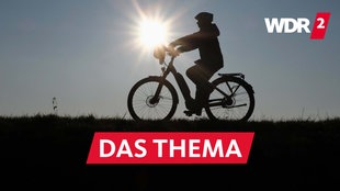 Archivfoto vom 10.11.2019: Nordrhein-Westfalen, Bislich: Eine Frau fährt bei untergehender Sonne mit ihrem Fahrrad über den Deich am Rhein. 