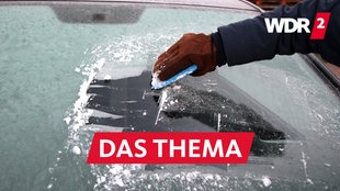 Eine vereiste Autoscheibe wird mit einem Eiskratzer vom Eis befreit