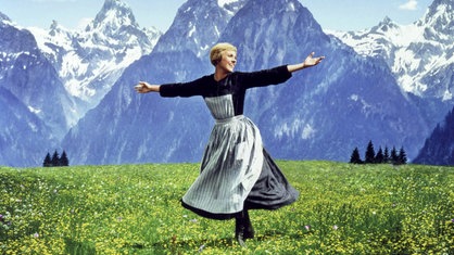 Das Beitragsbild des WDR3 Kulturfeature "Schnitzel with Noodles" zeigt die Schauspielerin Julie Andrews auf einer blühenden Bergwiese.