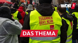 Aufschrift "Zusammen geht mehr. Verdi" auf einer Weste, die ein Mann auf einer Kundgebung der Gewerkschaft Verdi trägt