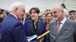 Frank-Walter Steinmeier (l) unterhält sich mit der Schriftstellerin Gaea Schoeters (M) und Nic Van der Marliere (r)