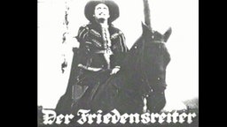 Filmausschnitt aus dem Stummfilm "Der Friedensreiter", in dem ein Mann mit Hut auf einem Pferd sitzt