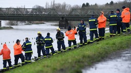 Mitarbeiter des Technischen Hilfswerks auf einem Deich