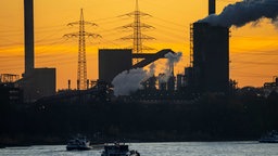 Sonnenuntergang mit Frachtschiffe auf dem Rhein vor Stahlwerk in Duisburg