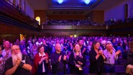 Das Publium der BBC Last Night of the Proms 2024 applaudiert mit den Bielefelder Philharmonikern mit stehenden Ovationen.