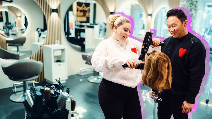 Eine Auszubildende übt Haare frisieren an einer Perücke