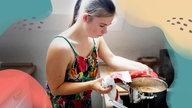 Eine junge Frau mit Down-Syndrom beim Kochen