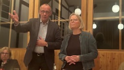 Friedrich Merz und eine Frau stehen nebeneinander