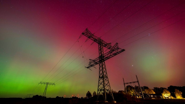 Polarlichzter am Himmel mit Silhoutten von Masten