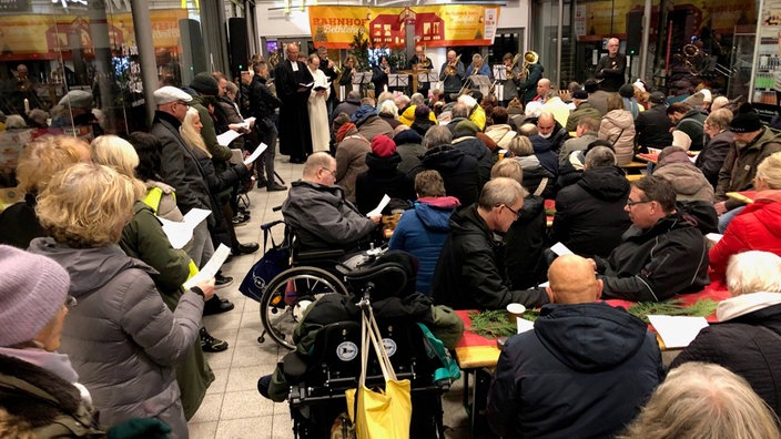 Menschen versammeln sich in Bielefeld für den "Bahnhof Betlehem", ein ökumenischer Gottesdienst