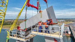 Luftaufnahme von der Montage des Abschlusselementes des ersten Pylons der Leverkusener Rheinbrücke.