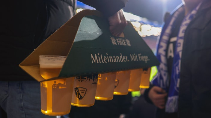 Fieges Pils im Becher in einer Trage im Stadion