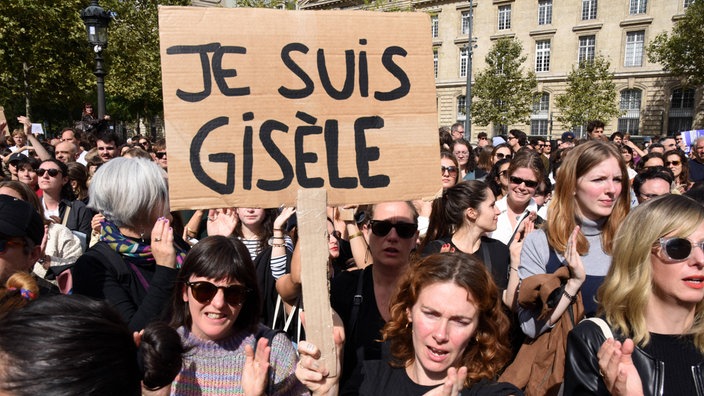 Bei der Demonstration zur Unterstützung von Gisele Pelicot in Paris hält eine Frau ein Schild mit der Aufschrift "Je suis Gisèle" ("Ich bin Gisèle") hoch.