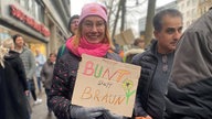 Demonstrantin Melanie Rohde aus Köln mit einem Schild "Bunt statt Braun"