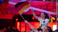 Ein Frau schwenkt beim Public Viewing in Dortmund die deutsche Fahne