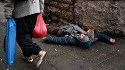 Eine Person liegt am 25. Januar 2024 auf der Straße im Viertel Old Town Chinatown in der Innenstadt von Portland, Oregon.