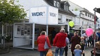 Menschen laufen am "WDR-Cube" vorbei