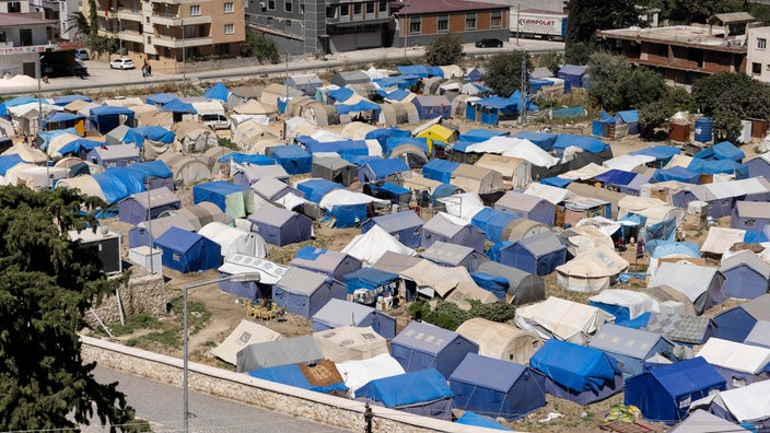 Antakya: Eine Zeltstadt wurde für die Überlebenden des Erdbebens im Stadtzentrum errichtet und liegt in der heißen Sommersonne. Notunterkünfte in der Hitze und Trümmerfelder. Sechs Monate nach den Erdbeben in der Südosttürkei.