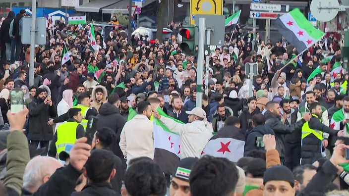 Demonstranten und Demonstrantinnen feiern auf den Straßen Essens, vereinzelt sind Flaggen zu sehen