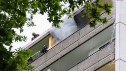 Einsatzkräfte versuchen, die Wohnung in dem Ratinger Hochhaus zu löschen.