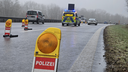 Polizeiwagen mit der Aufschrift "LANGSAM" auf einer glatten Autobahn