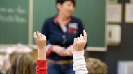 Grundschul-Leherin, Schüler mit Zeigefinger