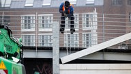 Mitarbeiter der Stadt Düsseldorf schließen das Tor am Unteren Rheinwerft zum Alten Hafen