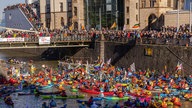 Demonstranten fahren mit Kanus und Kayaks über den Rhein