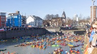 Demonstranten fahren mit Kanus und Kayaks über den Rhein