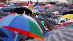 Ein Meer aus Schirmen beschützt am Sonntag (11.11.07) in Köln die Karnevalisten vor dem Regen.