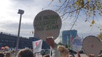 Menschen mit bunten Plakaten demonstrieren vor dem Landtag in Düsseldorf, auf einem steht: "Nicht Magerquark, Solidarität macht stark"