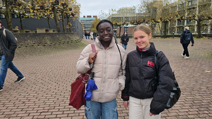 Zwei Studentinnen stehen auf dem Campus 