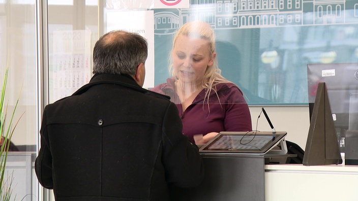 Ein Mann wird am Schalter in der Ausländerbehörde Krefeld betreut.