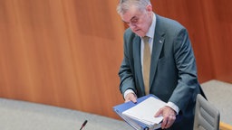 Herbert Reul (CDU), Innenminister von Nordrhein-Westfalen, mit einem Stapel Papier in der Hand