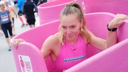 Frau in einem pinke Frauen-Urinal 