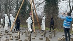 Aktivisten stehen in Lützerath auf einer Straße unter einer dreibeinigen Holzkonstruktion.