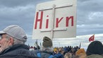 Ein Aktivist hält ein Schild mit der Aufschrift "Hirn"