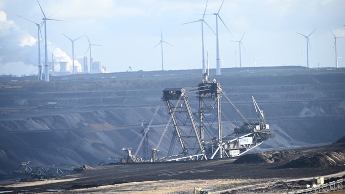 Im Vordergrund ist der Tagebau Garzweiler 2 und im Hintergrund befinden sich Windräder.