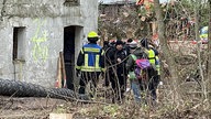 Feuerwehr und Polizei vor einem Tunnel in Lützerath