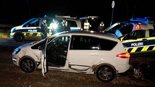 Bottrop: Ein beschädigtes Auto steht nach einer Verfolgungsjagd mit der Polizei neben Einsatzfahrzeugen