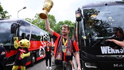 Lukas Hradecky kommt mit dem Pokal zum Schloss Morsbroich, um sich in das Goldene Buch der Stadt einzutragen.