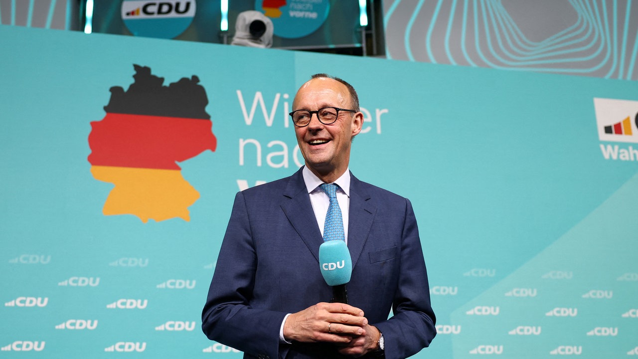 CDU-Kanzlerkandidat Friedrich Merz steht lächelnd auf der Bühne 