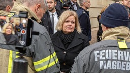 Nancy Faeser und Feuerwehr am Ort des Attentats in Magdeburg.