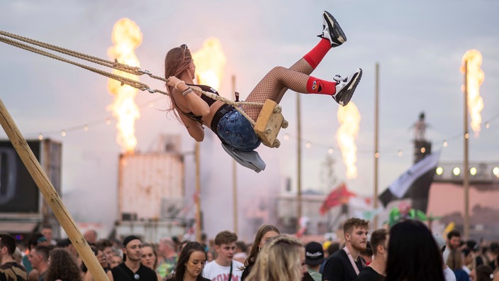 Eine Frau schaukelt auf dem Musikfestival Parookaville. Bei dem nach Veranstalterangaben größten Elektro-Festival Deutschlands treten rund 300 Künstler auf