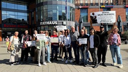 Leute protestieren gegen die Abschiebung von Sekou Sidibe mit Schildern