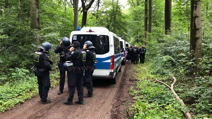 Eine große Gruppe von Polizisten in Einsatzkleidung im Wald.